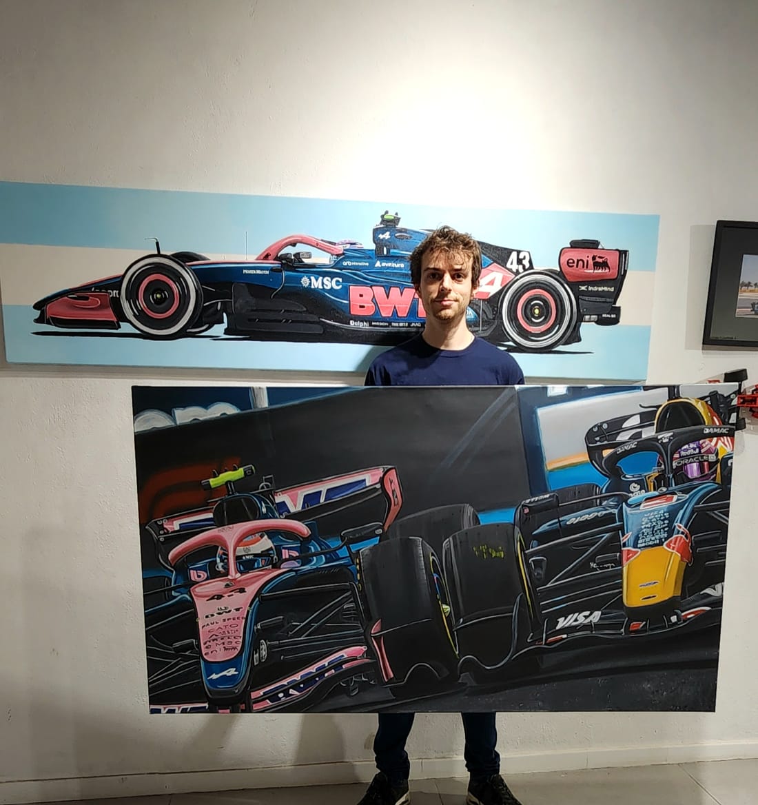 Fede Mejuto junto a dos de sus obras de Fórmula 1